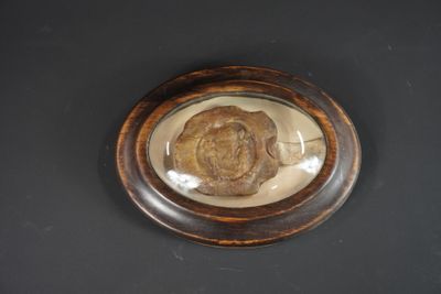Sceau en cire dans un cadre ovale et verre bombé.