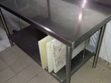 une table de travail en acier inoxydable avec une étagère en dessous