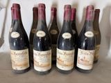 six bottles of red wine are lined up on a table