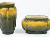 two vases sitting next to each other on a white surface