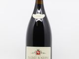 bottle of red wine sitting on a white surface with a white background