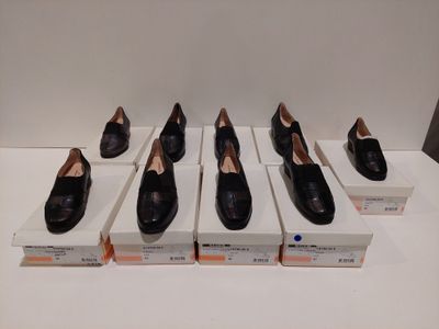 six paires de chaussures noires sont alignées sur une table blanche
