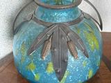 un vase bleu orné d'une feuille, posé sur une table
