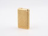 a gold cigarette case with a woven design on the front