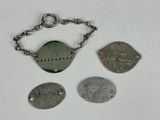 trois types différents d'étiquettes métalliques suspendues à une chaîne sur une surface blanche