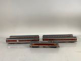 trois trains miniatures posés les uns à côté des autres sur une surface blanche
