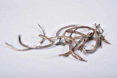 a pile of silverware on a white surface