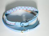 un collier de chien muni d'une boucle métallique posé sur une table blanche