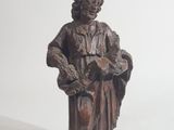 statue d'un homme coiffé d'un chapeau et vêtu d'une robe, tenant un livre