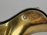 an antique brass pitcher with a curved neck and a curved handle