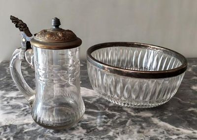 un pichet en verre et un saladier posés sur une table en marbre