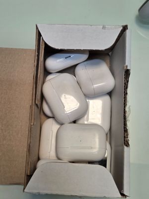 une boîte d'AirPods posée sur une table à côté d'une souris d'ordinateur