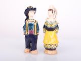two figurines of a man and a woman standing next to each other