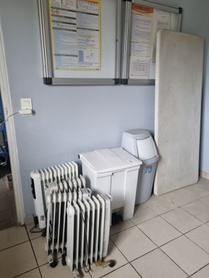 un radiateur situé dans un coin de la pièce, à côté des toilettes
