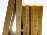 plusieurs vieux livres sont empilés sur une surface blanche