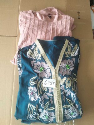 two shirts that are sitting on top of a cardboard box