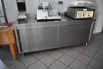 une cuisine équipée d'un plan de travail, d'un four et d'un ordinateur portable posé dessus