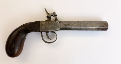 gros plan d'un pistolet sur une surface blanche