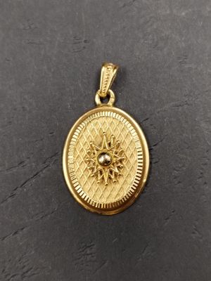 un pendentif en or orné d'un motif de tournesol