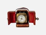 une petite horloge posée dans un écrin rouge