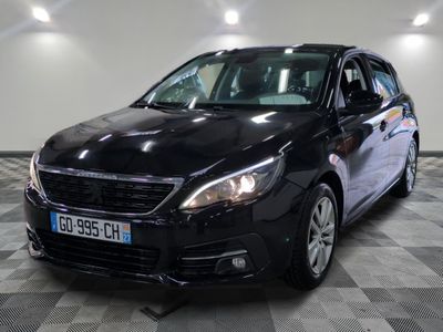 the black car is parked on a checkered floor in the garage
