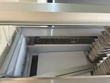 several pans are lined up on a conveyor belt in a commercial kitchen
