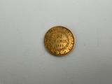 a close up of a gold coin on a white surface