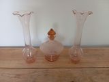 three vases sitting on a wooden table with a white wall in the background