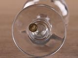 a wine glass with a gold coin inside of it