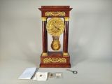 une horloge posée sur une table à côté d'une paire de ciseaux