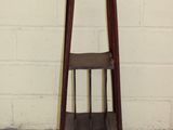 a small wooden stool with a shelf on it