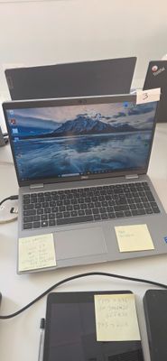 un ordinateur portable posé sur un bureau, à côté d'un téléphone portable