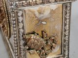 a silver clock with a bird on top of it