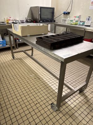 une grande table en métal sur laquelle est posé un plateau de nourriture