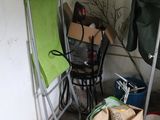 a green chair in the corner of a room next to a chair