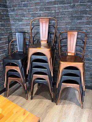 plusieurs chaises et une table dans une pièce aux murs en briques