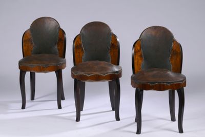 three wooden chairs with leather upholstered back and legs