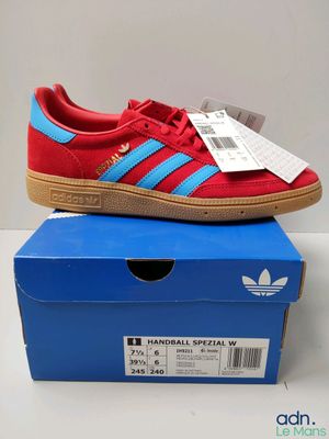 a pair of red and blue adidas sneakers sitting on top of a blue box