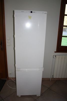 a white refrigerator in the corner of a room