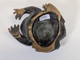 a black and gold frog figurine with a tag on it