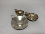 une tasse et une soucoupe argentées posées sur une table blanche