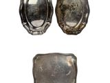 deux plateaux en argent et une assiette en argent sur fond blanc