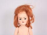 a small doll with a red hair on a white background