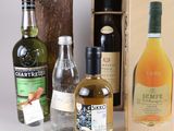 several bottles of alcohol are lined up next to a wooden box