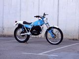 une moto bleue et blanche garée sur un parking
