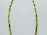 un collier en or avec une chaîne sur fond blanc