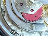 a close up of a watch with a red and white dial
