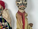 two dolls sitting next to each other on a white surface