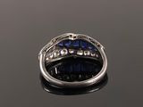a close up of a ring with blue sapphires and diamonds
