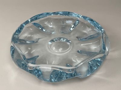 un saladier en verre transparent bordé de bleu, posé sur une table